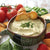 Spinach Artichoke Dip prepared with sour cream and cream cheese, served with crackers and veggies. 